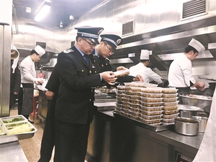 西城区德胜食药所工作人员正在对提供年夜饭的餐厅进行检查